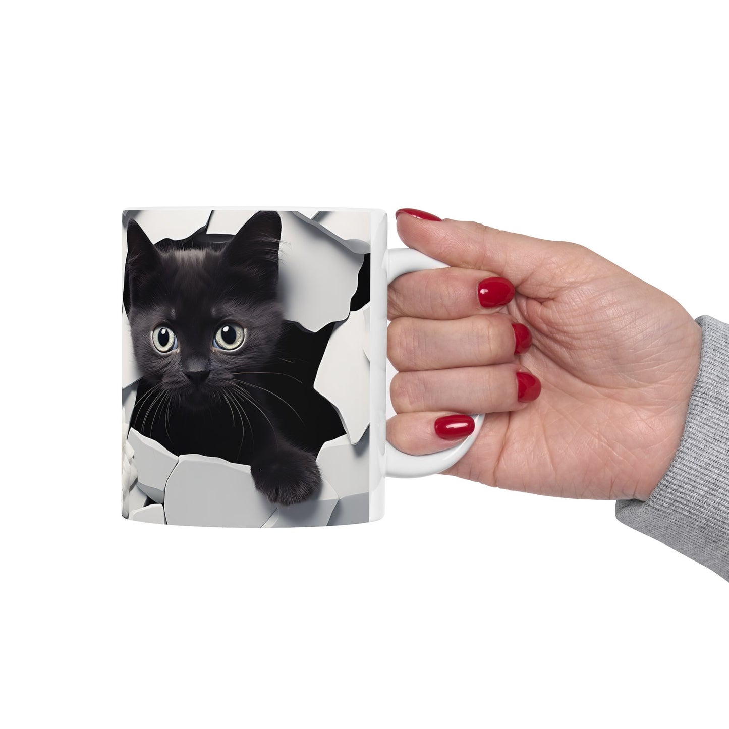 Hand holding a mug with a black cat design on a white background