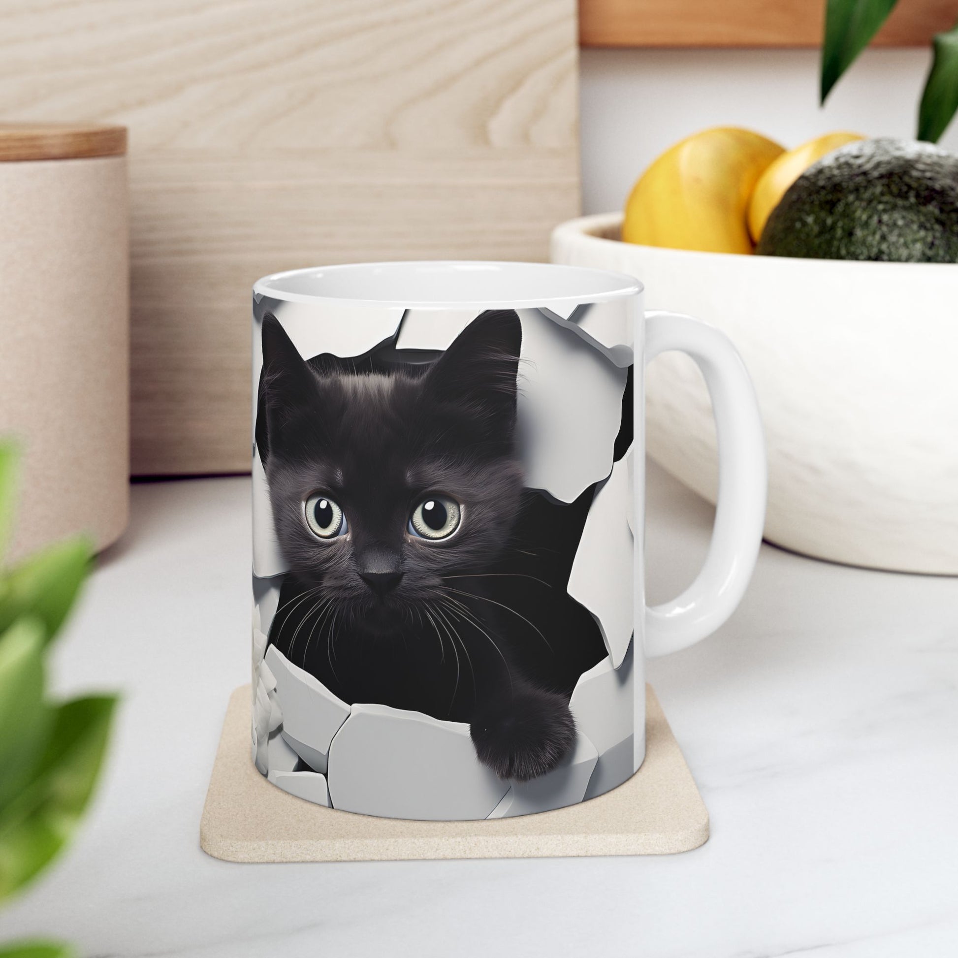 White mug with a black cat design on a coaster, placed on a kitchen counter.