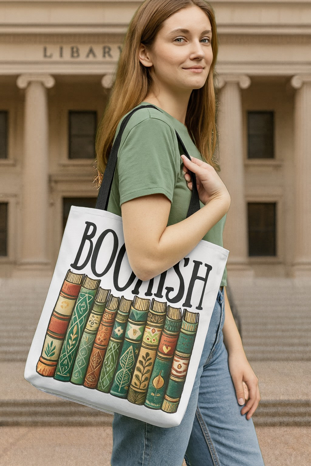 Woman holding a tote bag with 'Boohsh' design in front of a library.