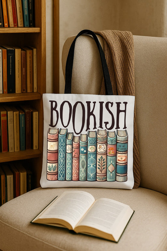 Tote bag with 'BOOKISH' text and book illustrations on a chair next to an open book and a bookshelf.