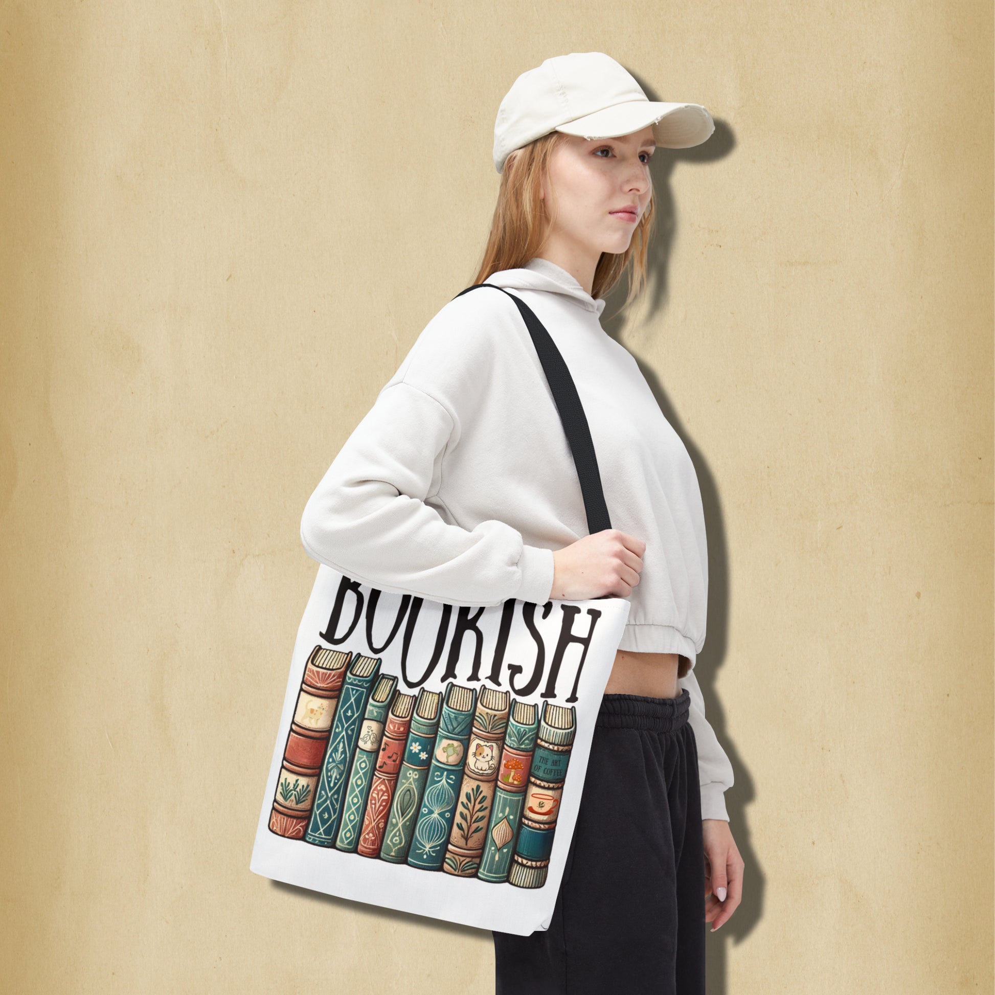Person holding a tote bag with 'BOOKISH' design against a beige background
