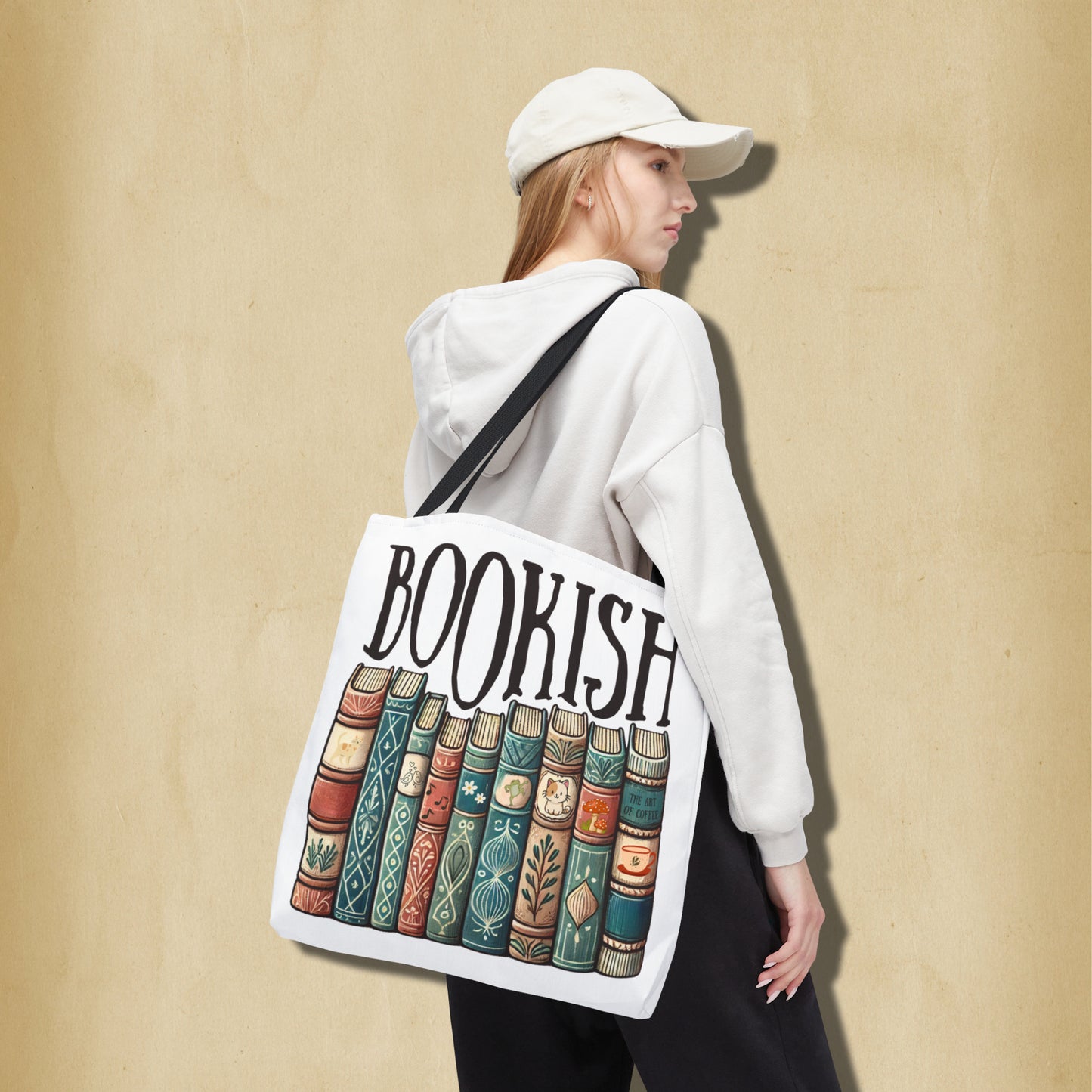 Person wearing a white hoodie and cap, carrying a tote bag with 'BOOKISH' and book design.