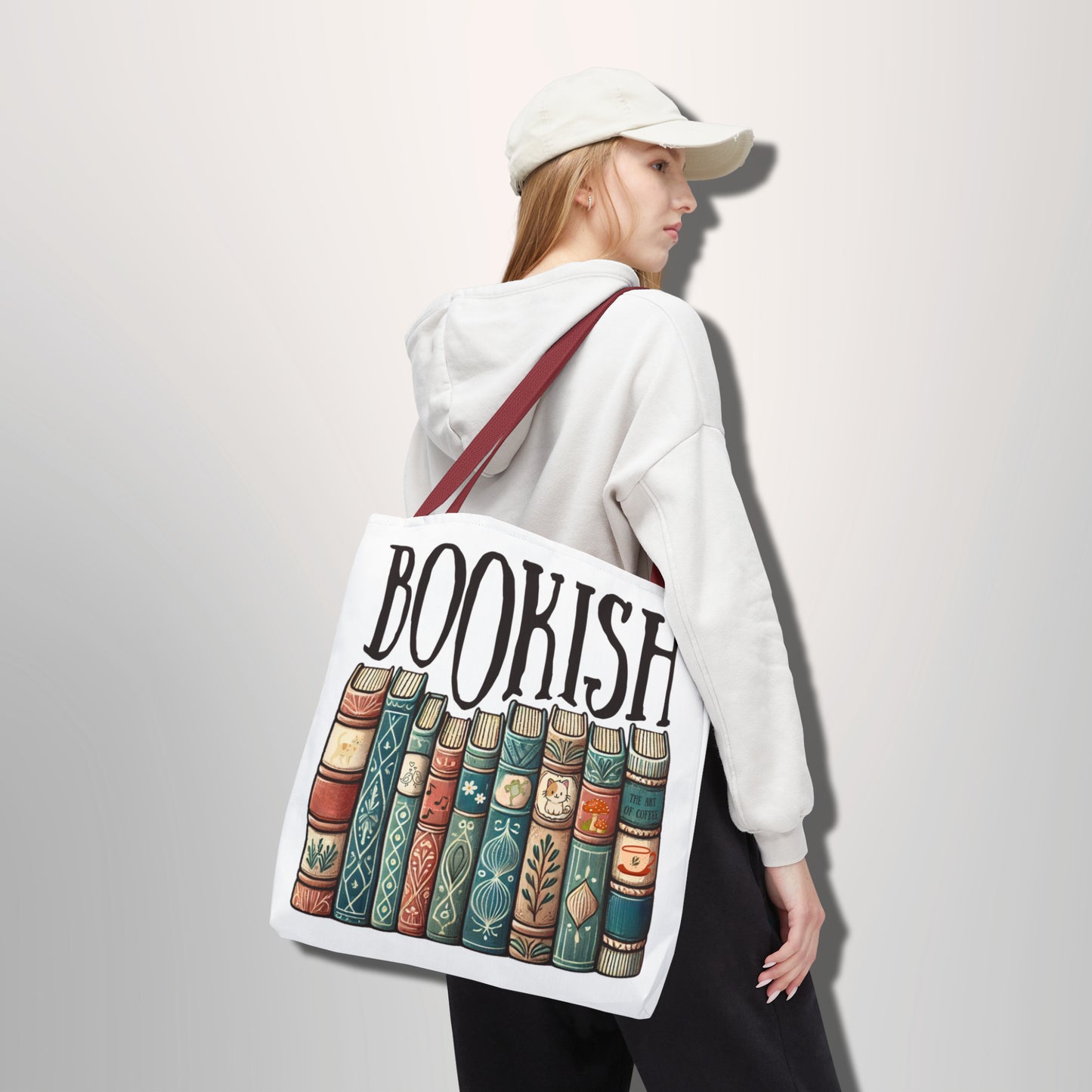 Person holding a tote bag with 'BOOKISH' design and book illustrations.