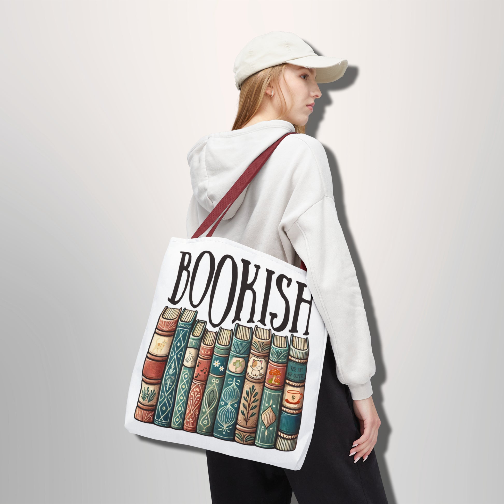 Person holding a tote bag with 'BOOKISH' design and book illustrations.